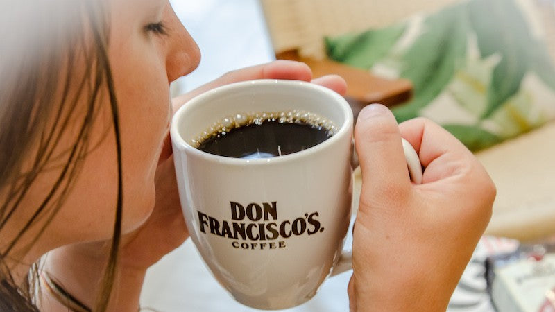 Woman enjoying a cup of coffee from a Don Francisco's Coffee mug